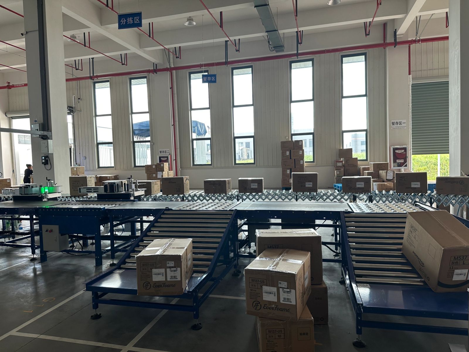 NetRay roller conveyor sorting line with curved flexible conveyor transfers in a fulfillment center