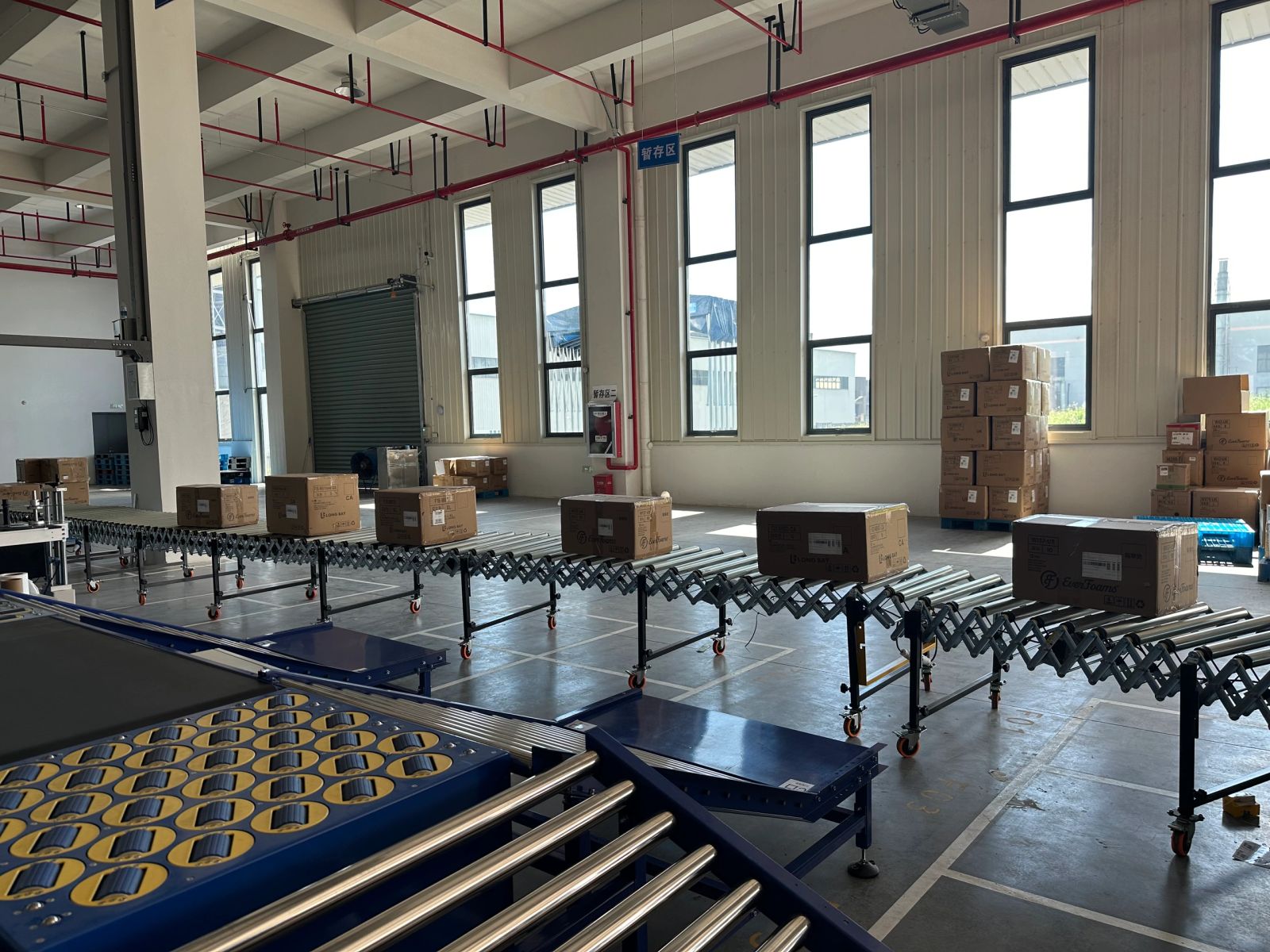 NetRay flexible expandable conveyors and wheel divert sorter in a warehouse staging area